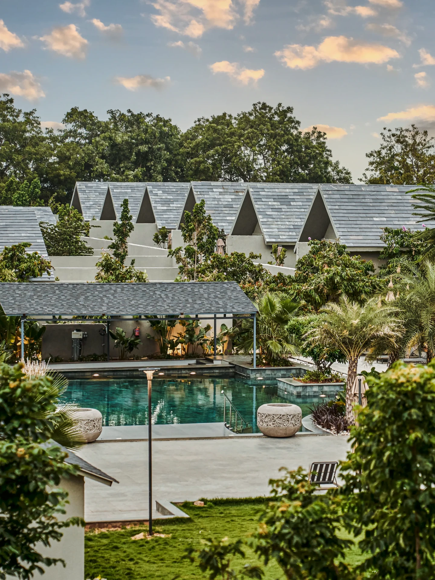 Villa rooftops and a pool surrounded by greenery